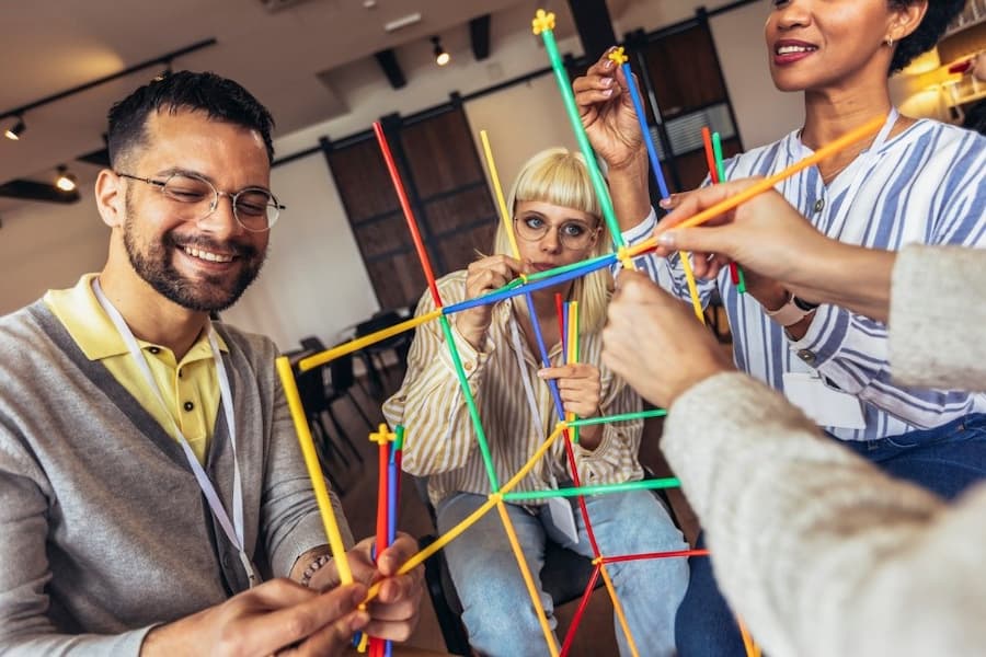 A group of people playing with colourful sticks