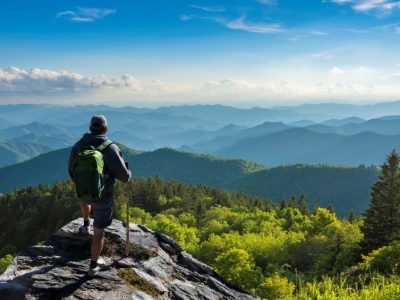 A person standing on a rock looking at a valley