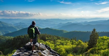 A person standing on a rock looking at a valley