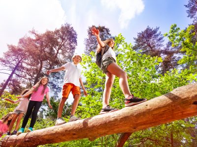 A group of kids walking on a log