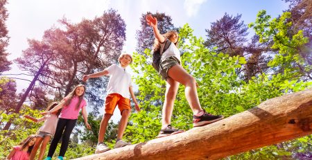 A group of kids walking on a log